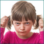 unhappy little girl making fists