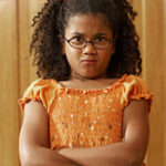 young girl crossing arms in defiance