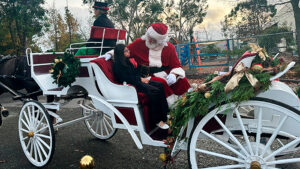 riding in the sleigh with Santa and his elf